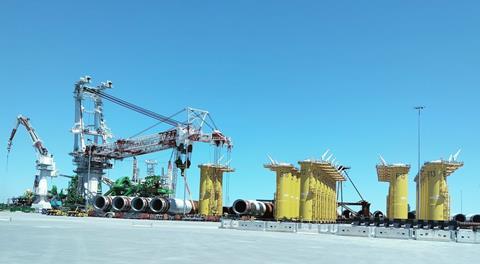 Credit - GDLM. Portsmouth Marine Terminal marshalling yard for the Coastal Virginia Offshore Wind development, with DEME’s Orion behind monopiles and transition pieces LO RES