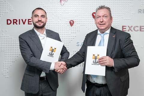 Andrei Geikalo, founder of MYCRANE, left, and Dorus Everwijn, managing director of PESCO Switzerland AG, right, celebrate the signing of the MoU.  MYCRANE